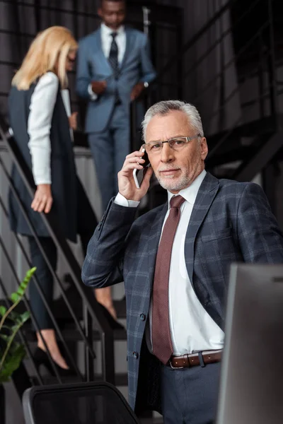 Selective Focus Handsome Businessman Glasses Talking Smartphone Multicultural Partners — Stock Photo, Image