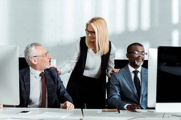 Glad Blond Kvinna Leende När Står Nära Mångkulturella Partners — Stockfoto