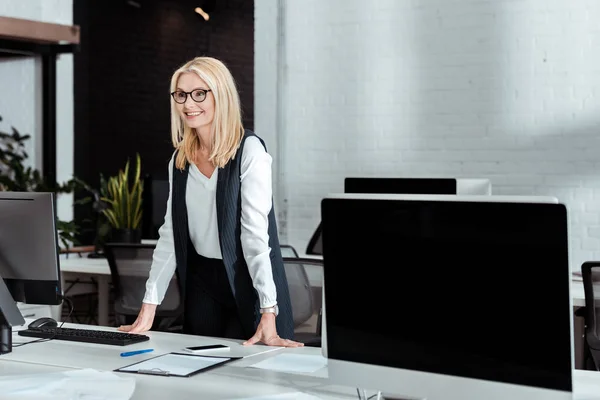 Fröhliche Blonde Geschäftsfrau Mit Brille Steht Neben Schreibtisch Büro — Stockfoto