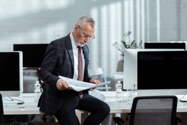ofiste planları bakarak gözlük yakışıklı işadamı 