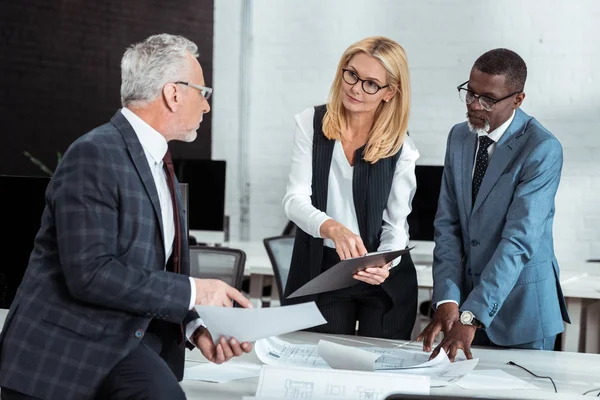 Attractive Businesswoman Holding Clipboard Gesturing Multicultural Partners — Stock Photo, Image