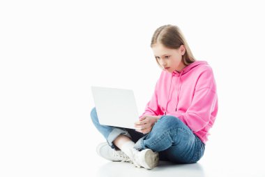 Beyaz, açıklayıcı editoryal üzerinde izole dizüstü bilgisayar kullanarak çapraz bacaklar ile üzgün genç kız