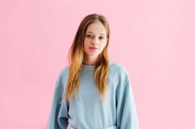 beautiful smiling teenage girl looking at camera isolated on pink