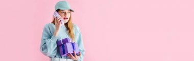 pembe üzerinde izole telefon olarak Cap Holding mevcut sürpriz güzel genç kız panoramik çekim