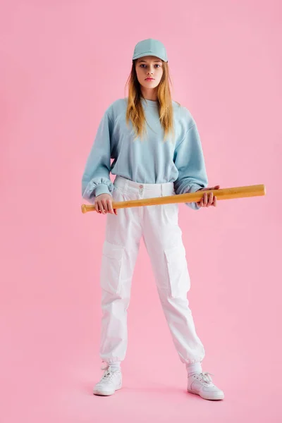 ピンクの上に野球のバットを保持キャップの十代の女の子の完全な長さのビュー — ストック写真