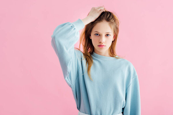 грустная девушка-подросток касается головы, изолированной на розовый
