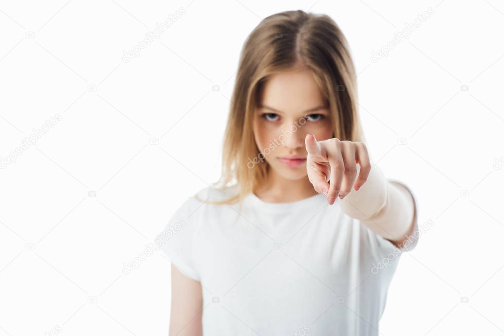 selective focus of offended teenager pointing with finger at camera isolated on white