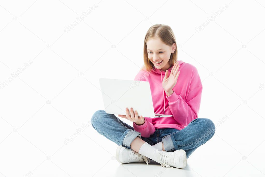 happy smiling teenage girl waving hand in laptop screen during video chat isolated on white, illustrative editorial