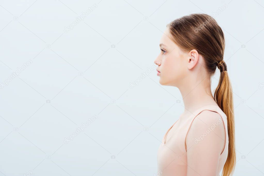 side view of serious teenage girl isolated on grey