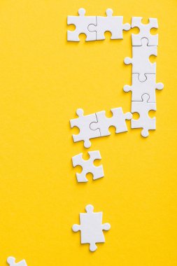 top view of connected white jigsaw puzzle pieces isolated on yellow  clipart