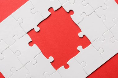 top view of unfinished white jigsaw puzzles isolated on red clipart