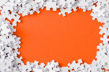 top view of frame with white jigsaw puzzle pieces isolated on orange clipart