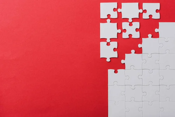 Draufsicht Auf Unfertige Und Weiße Puzzleteile Isoliert Auf Rot — Stockfoto
