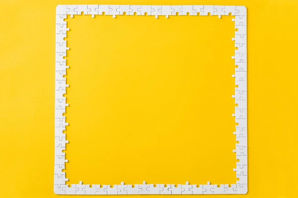 Widok Góry Ramki Połączonych Białych Puzzli Kawałki Izolowane Żółto — Zdjęcie stockowe