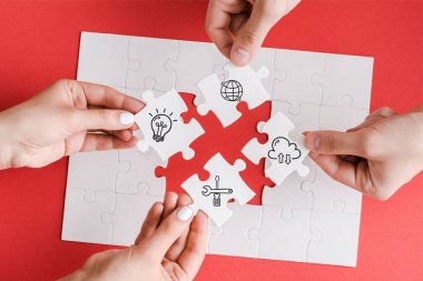 top view of man and woman holding white puzzle pieces with illustration on white  clipart