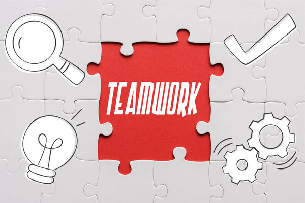 top view of connected jigsaw puzzle pieces near teamwork letters 