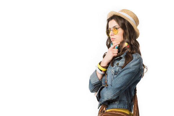 задумчивая бохо девушка в джинсовой куртке и соломенной шляпе глядя в сторону изолированы на белом
