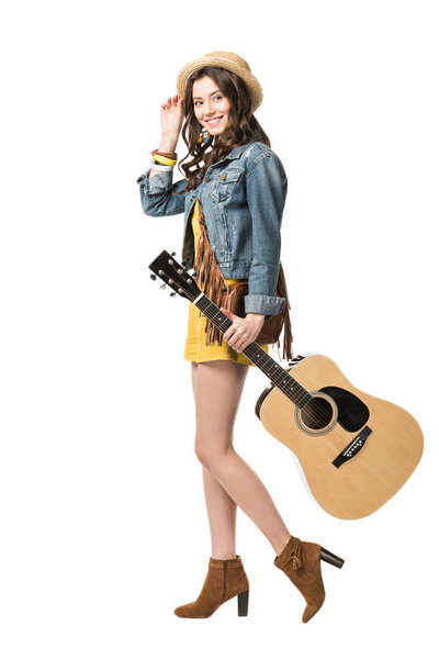 full length view of smiling hippie girl holding acoustic guitar isolated on white