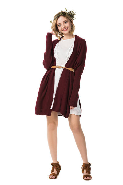 Вид в полный рост взволнованной девушки в венке и кардигане, изолированной на белом
