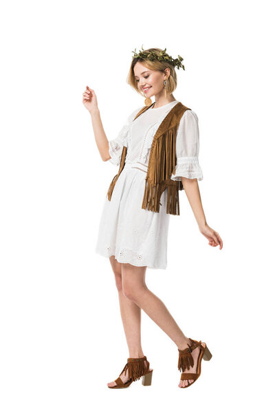 Вид в полный рост улыбающейся девушки в венке, изолированной на белом
