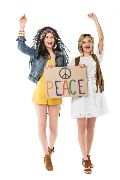 two bisexual hippie girls in indian headdress and wreath holding placard with inscription isolated on white