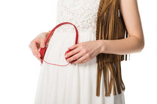 обрезанный вид беременной хиппи женщины с наушниками на животе изолированы на белом
