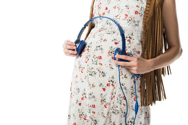 裁剪视图的孕妇拿着耳机在腹部隔离在白色 — 图库照片