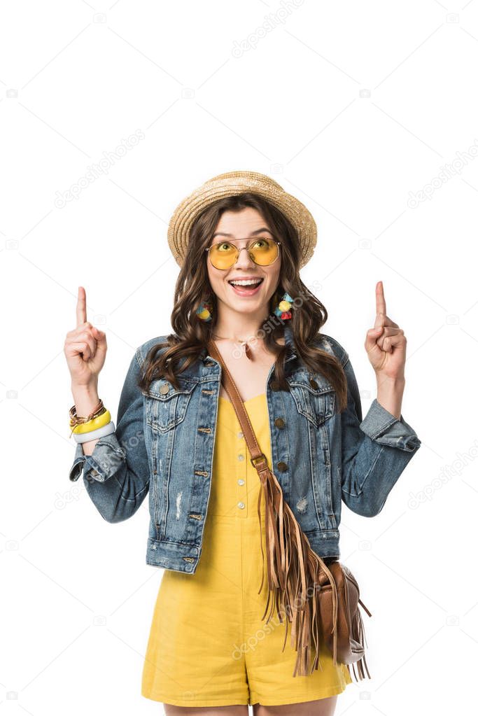 smiling boho girl in sunglasses and boater showing idea signs and looking up isolated on white