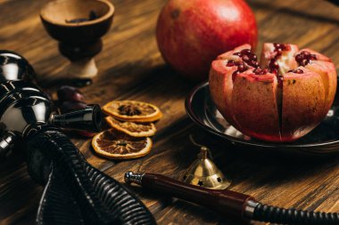 ahşap yüzeyüzerinde garnet, kurutulmuş portakal ve nargile