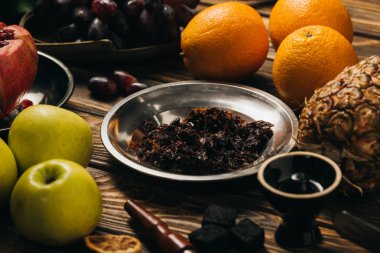 ahşap yüzeyde tütün, nargile, kömür ve taze meyve