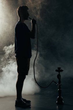 karanlıkta nargile içen siluet tam uzunlukta görünümü