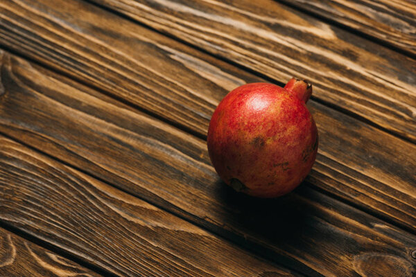 top view of ripe pomegranate on wooden surface