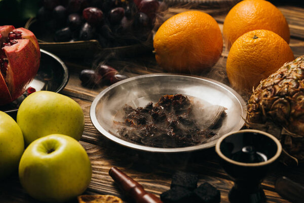 табак, кальян, уголь и свежие фрукты на деревянной поверхности
