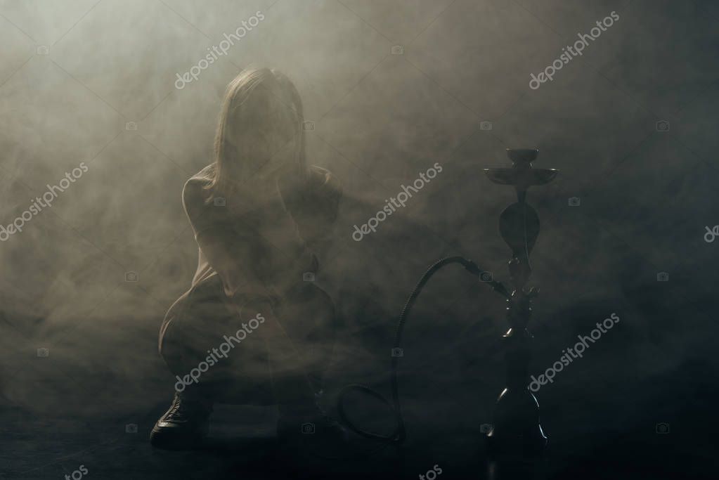 silueta de mujer joven fumar narguile en el humo 2024