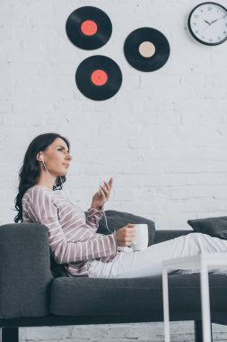 kanepede otururken ve kulaklıkla müzik dinlerken rüya gibi bir kadın