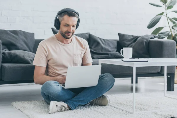 Handsome Man Headphones Sitting Floor Crossed Legs Using Laptop — Stock Photo, Image