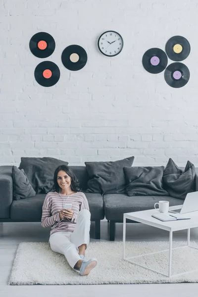 Cheerful Woman Listening Music Earphones Holding Smartphone While Sitting Floor — Stock Photo, Image