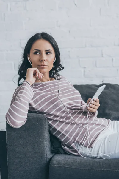 Thoughtful Woman Looking Away While Holding Smartphone Listening Music Earphones — Stock Photo, Image