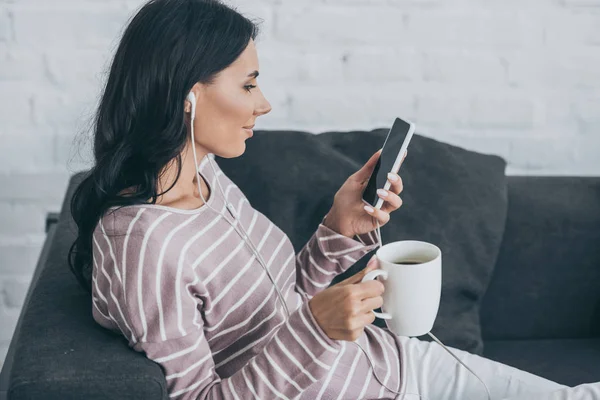 Mujer Sonriente Usando Teléfono Inteligente Mientras Escucha Música Los Auriculares —  Fotos de Stock