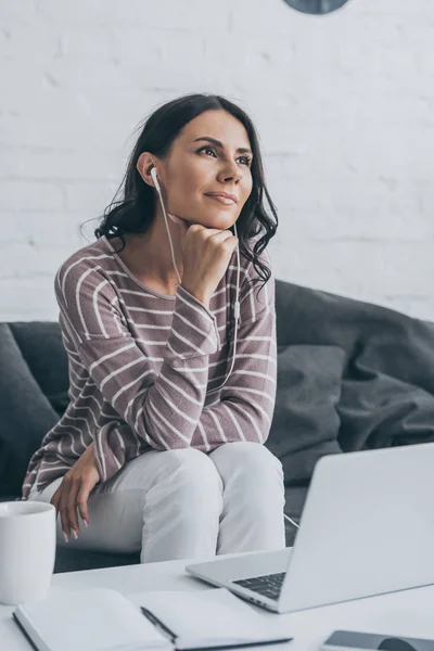 Marzycielski Kobieta Patrząc Siedząc Przy Stole Laptopem Słuchania Muzyki Słuchawkach — Zdjęcie stockowe