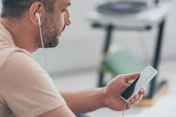 Adult Man Listening Music Earphones While Holding Smartphone Blank Screen — Stock Photo, Image