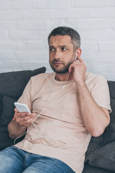 Thoughtful Man Looking Away While Listening Music Earphones Holding Smartphone — Stock Photo, Image
