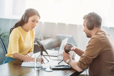 radyo stüdyosunda işyerinde otururken konuşan iki ciddi radyo hosts