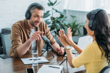 radyo stüdyosunda podcast kaydederken iki radyo hosts konuşma ve gesturing