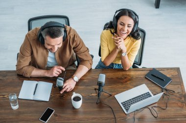 ahşap masada otururken iki neşeli radyo hosts kayıt podcast havai görünümü 