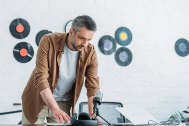 yakışıklı radyo host radyo stüdyosunda işyerinde dururken dizüstü bakarak