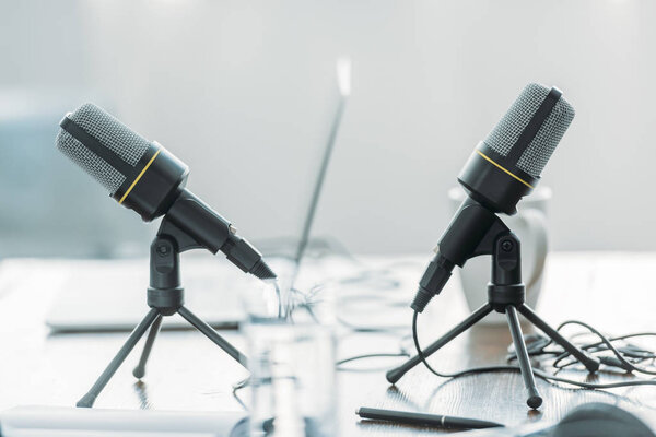 селективное фокусирование двух микрофонов на деревянном столе в студии вещания
