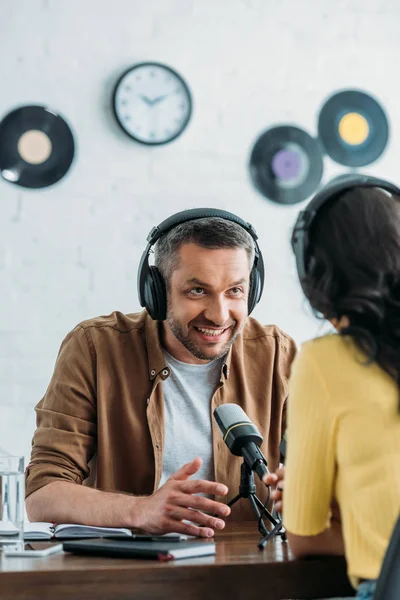 Lächelnder Radiomoderator Gestikuliert Gespräch Mit Kollegen Arbeitsplatz — Stockfoto