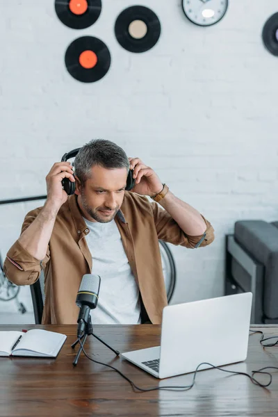 Handsome Radiovärd Håller Sätta Hörlurar Medan Tittar Laptop — Stockfoto