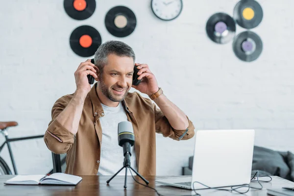 Schöner Radiomoderator Schaut Arbeitsplatz Auf Laptop Und Setzt Kopfhörer Auf — Stockfoto